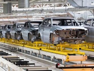 Automotive bodies moving on a friction conveyor system in a manufacturing plant