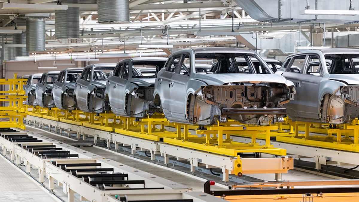 Automotive bodies moving on a friction conveyor system in a manufacturing plant